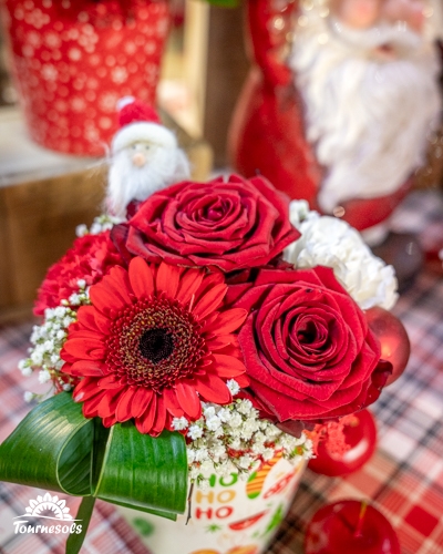 Bouquet de fleurs rouges avec décorations de Noël en arrière-plan.